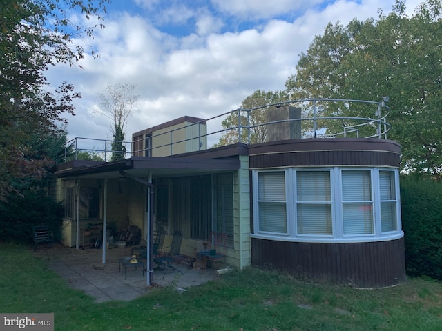 rear view of property featuring a lawn