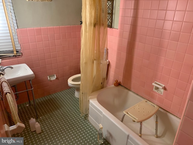 full bathroom featuring shower / bath combo, tile floors, tile walls, sink, and toilet