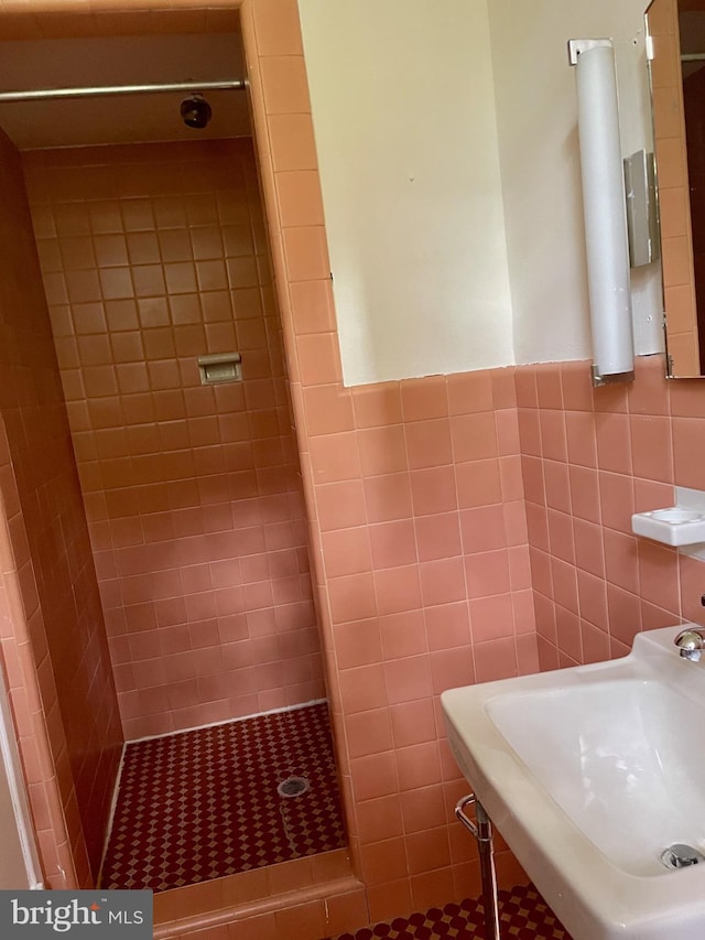 bathroom featuring sink, tile walls, and a tile shower