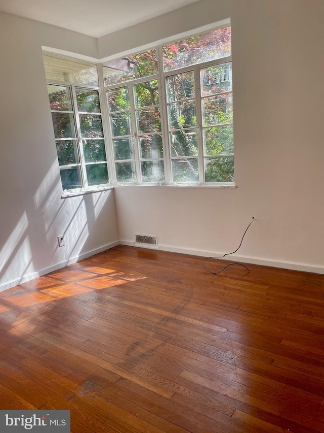 empty room with dark hardwood / wood-style flooring