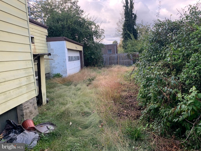 view of yard featuring a garage and an outdoor structure