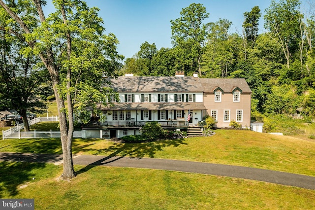 view of front facade featuring a wooden deck and a front lawn