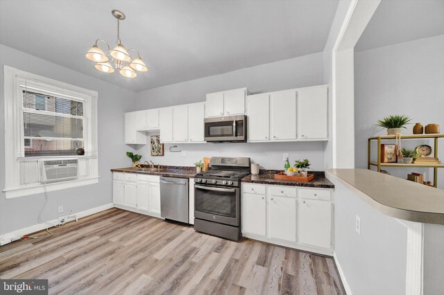 kitchen with stainless steel appliances, light hardwood / wood-style floors, and white cabinetry