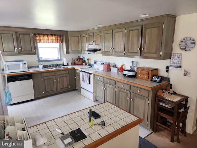 kitchen featuring range hood, white appliances, tile counters, and light tile floors