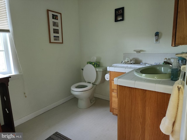 bathroom featuring toilet, tile floors, and vanity