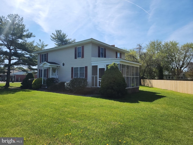 view of front facade with a sunroom and a front yard