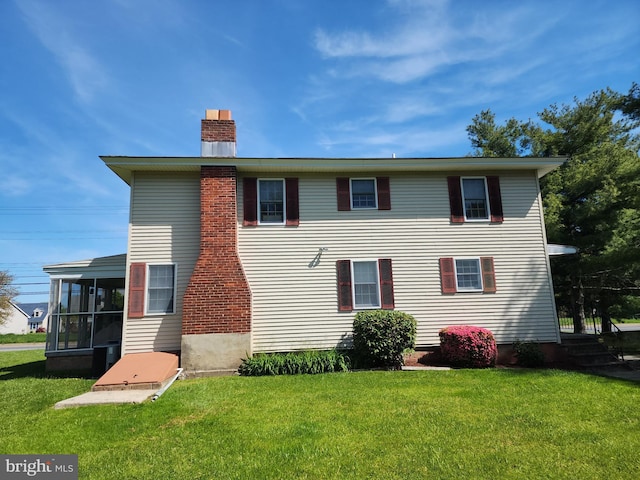 view of front of home with a sunroom and a front yard