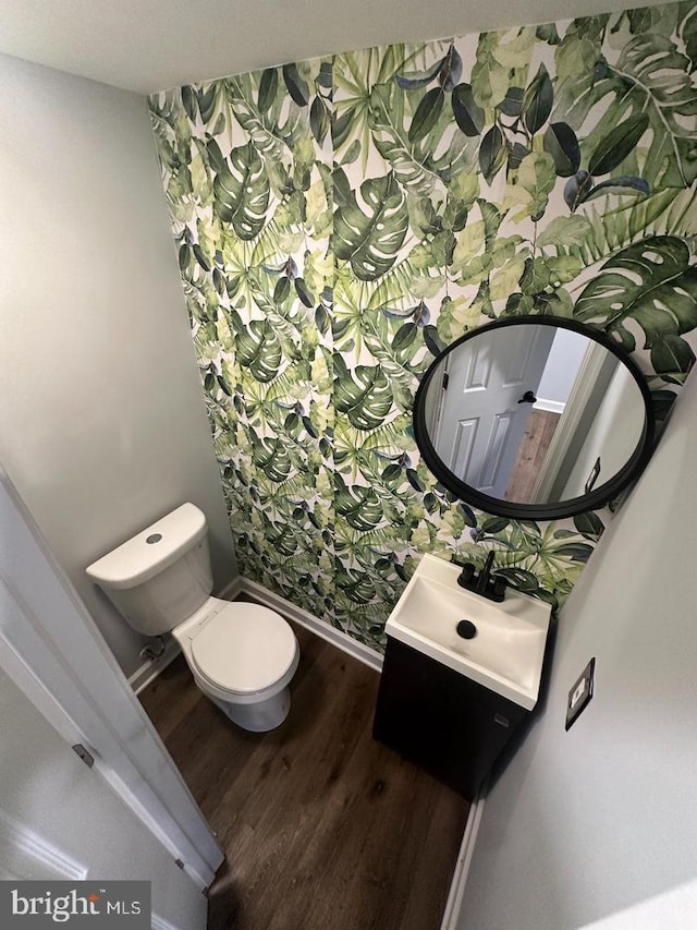 bathroom with toilet, vanity, and hardwood / wood-style flooring