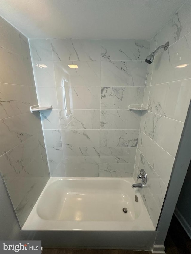 bathroom featuring tiled shower / bath