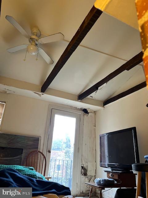 interior space with ceiling fan and vaulted ceiling with beams