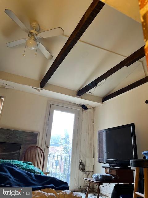 interior space with ceiling fan and vaulted ceiling with beams