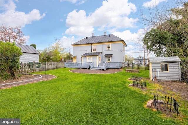 rear view of property featuring a storage shed and a lawn