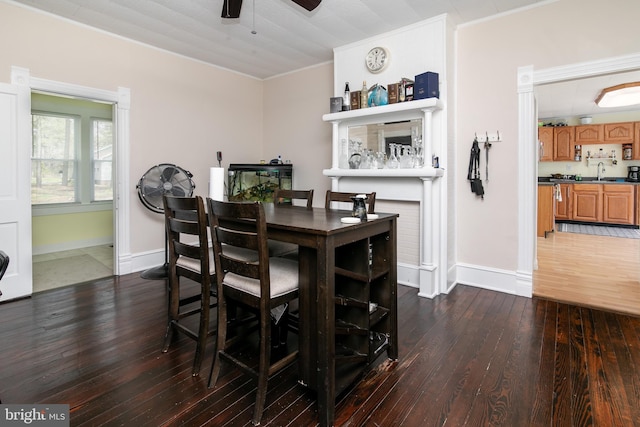 dining area with sink, ceiling fan, dark tile floors, and crown molding