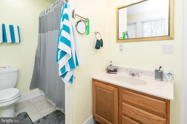 bathroom featuring tile floors, vanity, and toilet