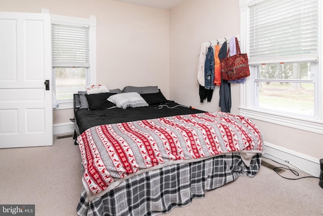 carpeted bedroom featuring multiple windows