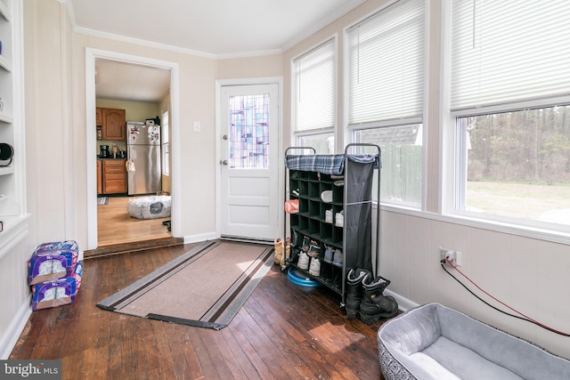 workout room featuring dark wood-type flooring, built in shelves, and ornamental molding