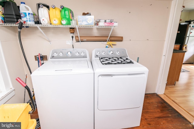 clothes washing area featuring wood-type flooring and washer and dryer