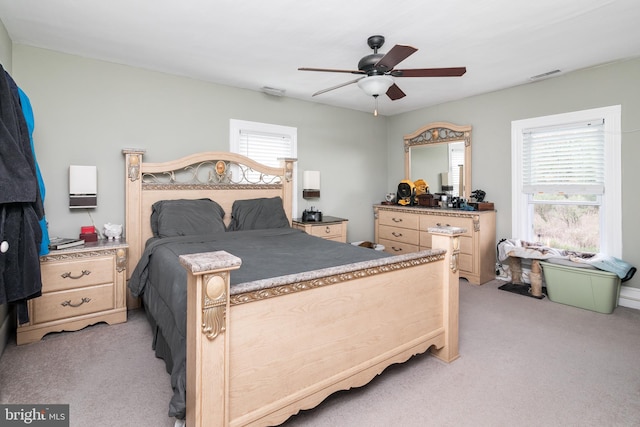 bedroom with ceiling fan and light carpet