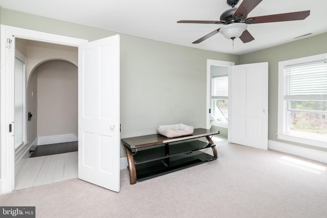 interior space with ceiling fan and light carpet