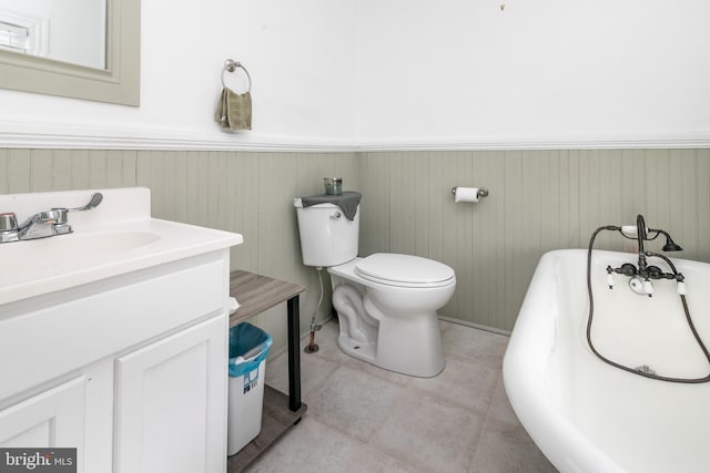 bathroom featuring tile floors, vanity, a tub, and toilet