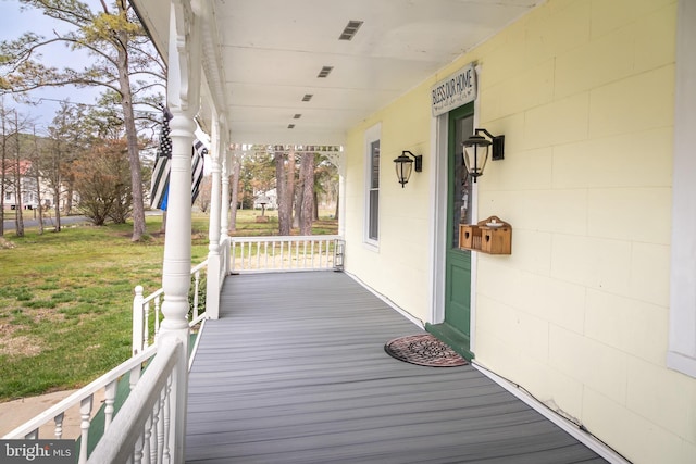 wooden terrace featuring a lawn