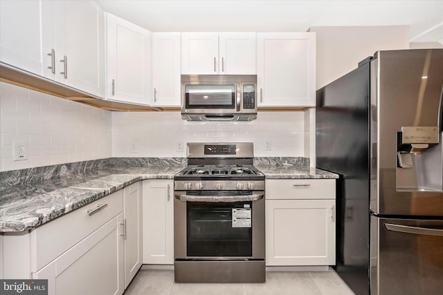 kitchen featuring light stone counters, appliances with stainless steel finishes, white cabinetry, and tasteful backsplash