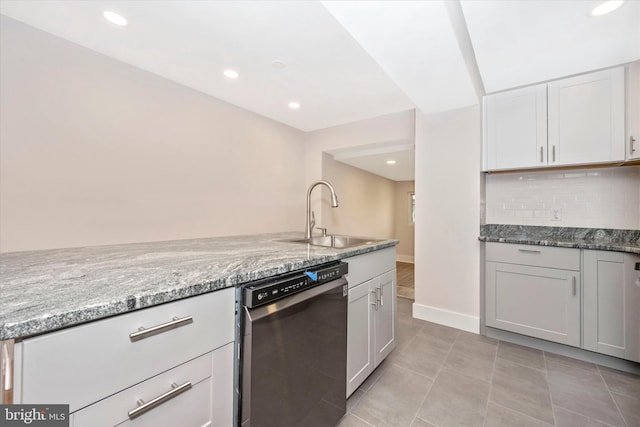 kitchen with dishwasher, tasteful backsplash, light stone countertops, sink, and light tile floors