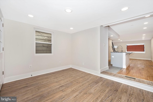 unfurnished living room with hardwood / wood-style floors and sink