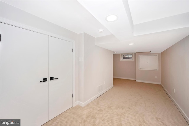 basement featuring light colored carpet