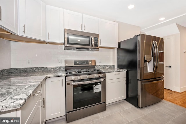 kitchen featuring stainless steel appliances, light hardwood / wood-style flooring, and white cabinets