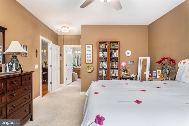 carpeted bedroom featuring ensuite bath and ceiling fan