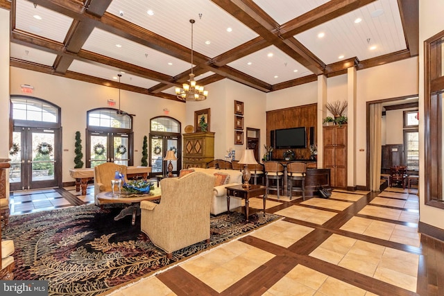 tiled living room with french doors, a notable chandelier, and a towering ceiling