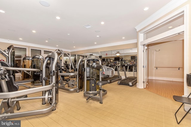 gym with ornamental molding and light hardwood / wood-style floors