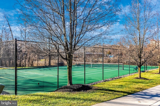 view of tennis court featuring a lawn and basketball court