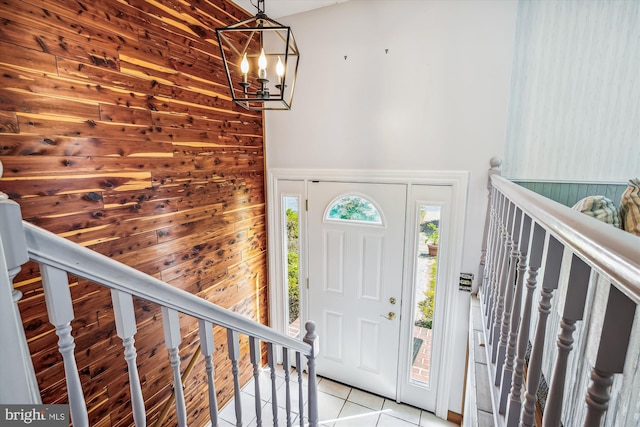 tiled foyer with a notable chandelier