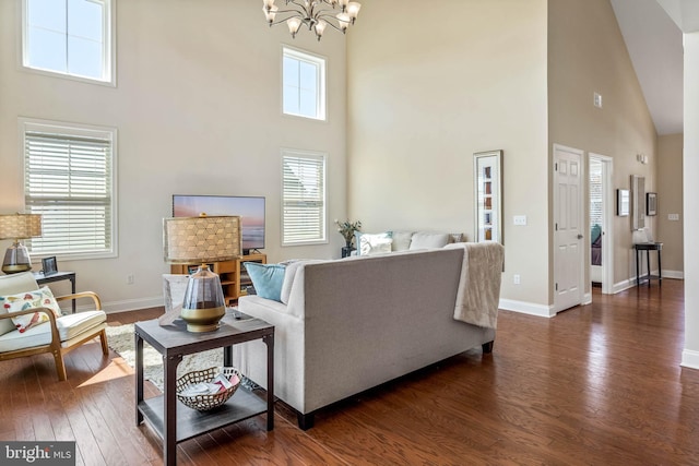 living room with dark hardwood / wood-style flooring, a high ceiling, and a notable chandelier