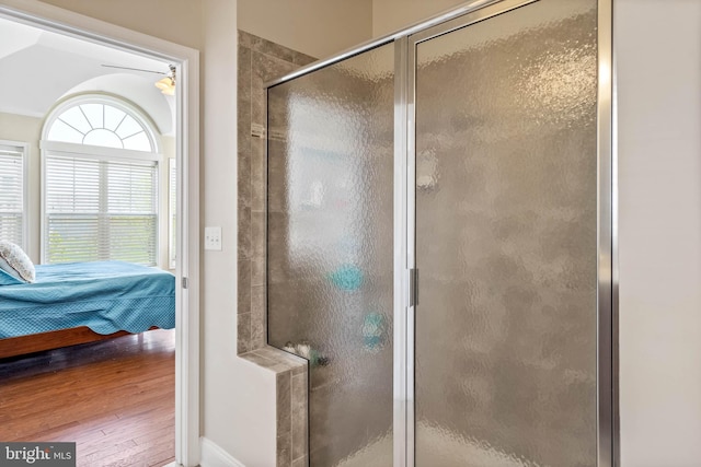 bathroom featuring hardwood / wood-style flooring, walk in shower, and lofted ceiling