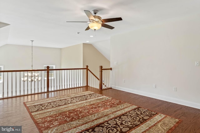 interior space with vaulted ceiling, hardwood / wood-style floors, and ceiling fan with notable chandelier