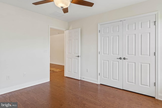 unfurnished bedroom with ceiling fan, a closet, and dark hardwood / wood-style floors