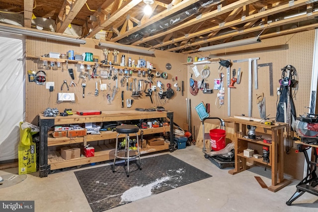 miscellaneous room with a workshop area and concrete flooring