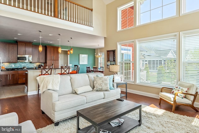 living room featuring a towering ceiling, dark hardwood / wood-style floors, and a notable chandelier