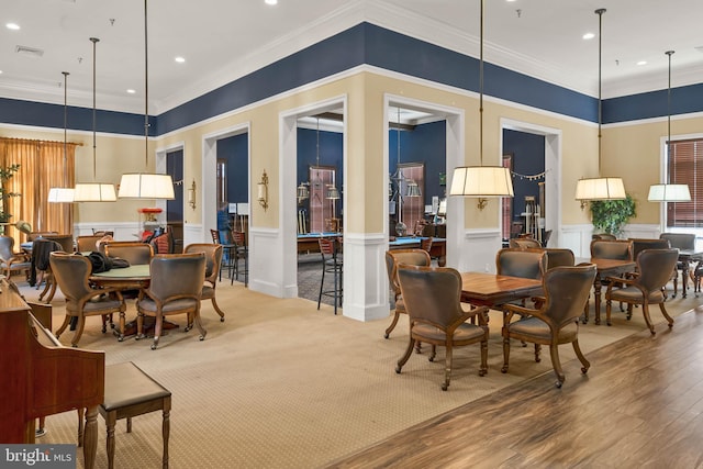 dining area with hardwood / wood-style flooring and crown molding