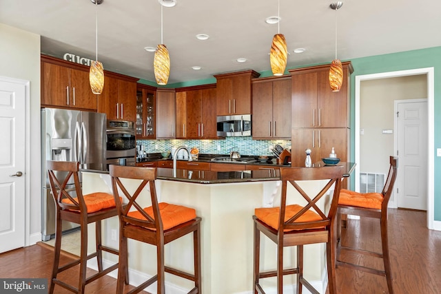 kitchen featuring dark wood-type flooring, pendant lighting, and stainless steel appliances