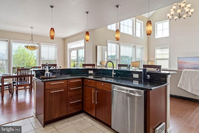 kitchen with light hardwood / wood-style flooring, stainless steel dishwasher, and plenty of natural light