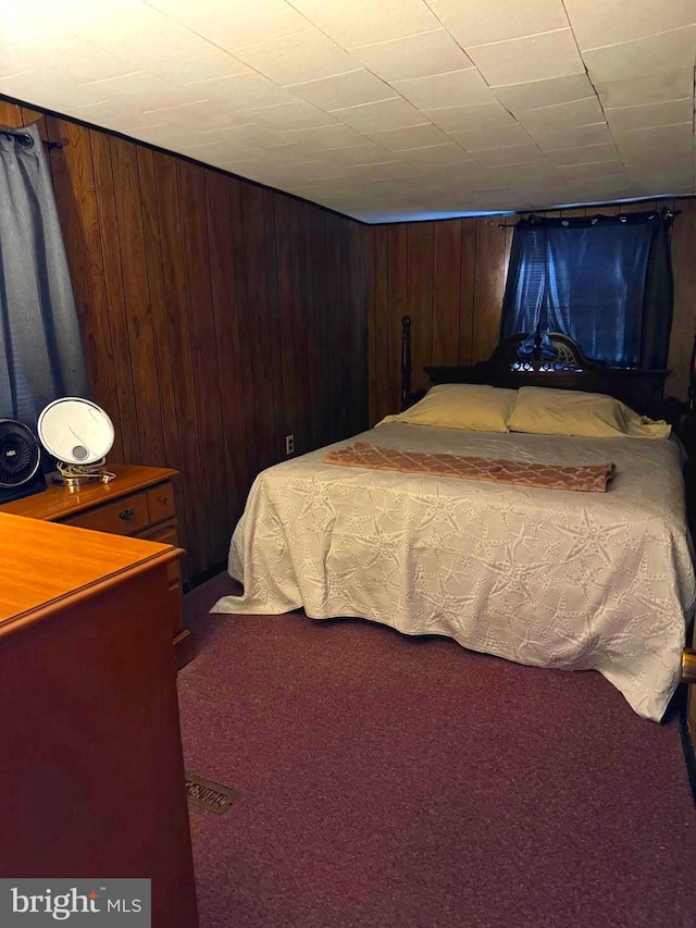 bedroom with carpet and wooden walls