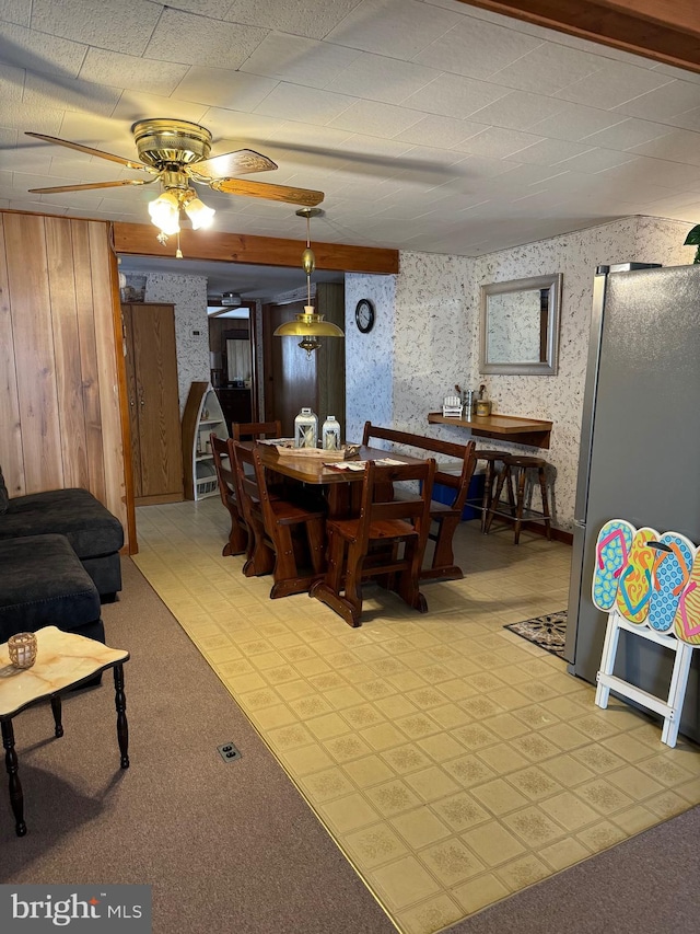 interior space with wooden walls, light colored carpet, and ceiling fan