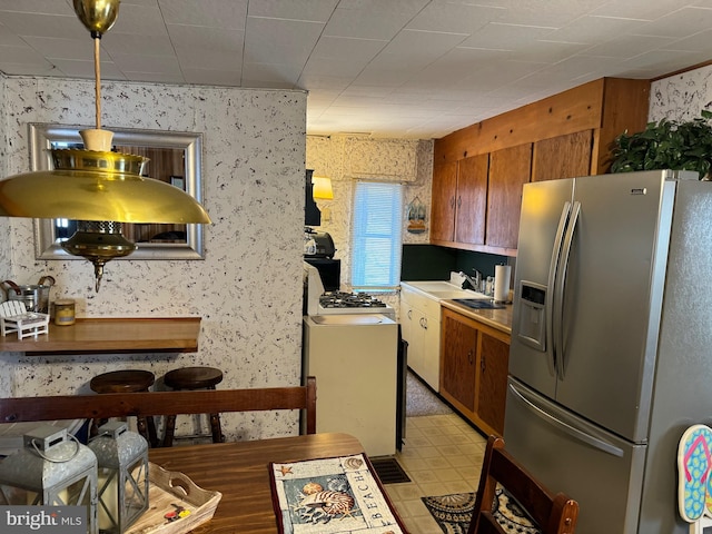 kitchen with stainless steel fridge with ice dispenser, light tile floors, and pendant lighting