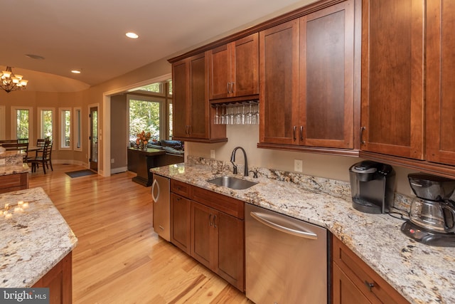 kitchen featuring light stone countertops, light hardwood / wood-style floors, dishwasher, sink, and a chandelier