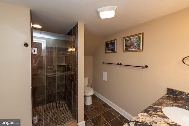 bathroom featuring walk in shower, vanity, toilet, and tile flooring