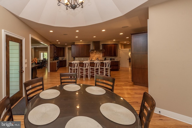 dining space featuring an inviting chandelier and light hardwood / wood-style flooring